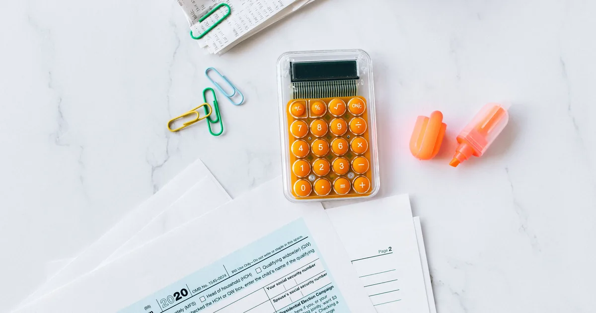 Tax documents and a calculator on an office desk