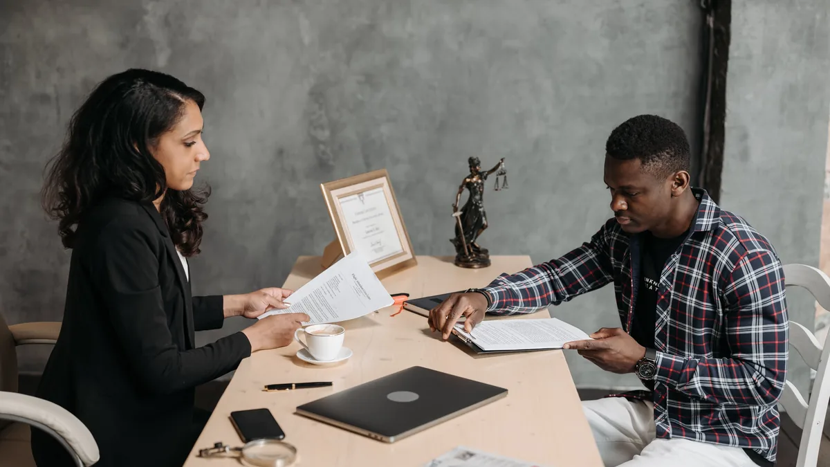 An adviser explaining branch registration requirements to a client in a meeting room