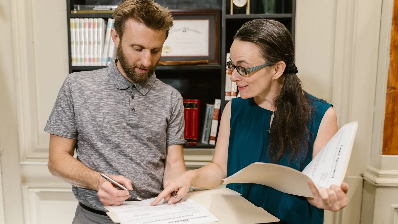An adviser and a founder going through incorporation paperwork at a desk