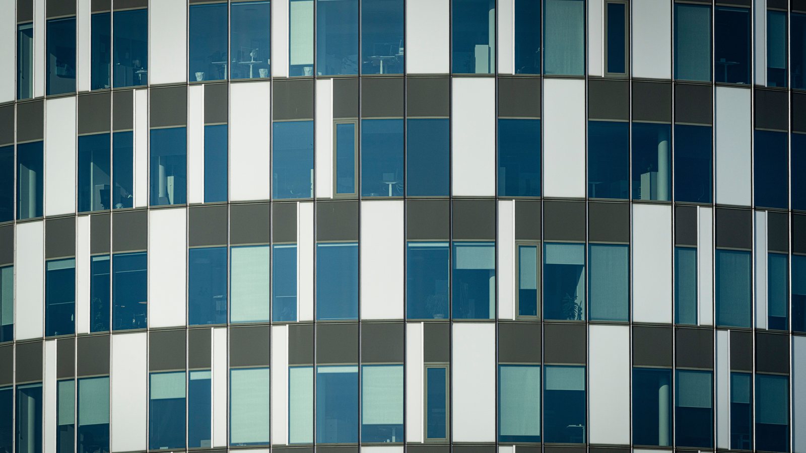 Glass facade of a modern office building housing an innovative startup in Italy.