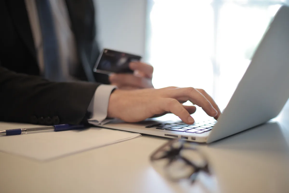 A person submitting a form online from a laptop